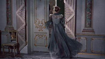 Movie still from “War and Peace” (1956), directed by King Vidor – A woman in a long dress walking in front of a door; Wide shot, High angle