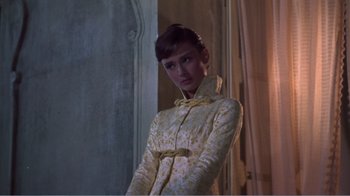 Movie still from “War and Peace” (1956), directed by King Vidor – A woman in a yellow dress standing in front of a window; Medium shot, Over the shoulder angle