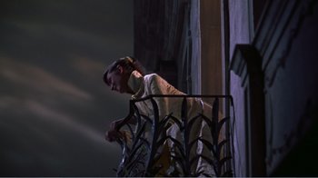 Movie still from “War and Peace” (1956), directed by King Vidor – A man standing on a balcony looking out the window; Medium shot, Low angle
