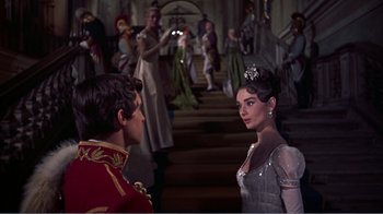 Movie still from “War and Peace” (1956), directed by King Vidor – A man and a woman are standing next to each other in front of a crowd; Medium shot, Over the shoulder angle