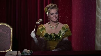 Movie still from “War and Peace” (1956), directed by King Vidor – A woman in a green and yellow dress holding a flower; Medium shot, Low angle