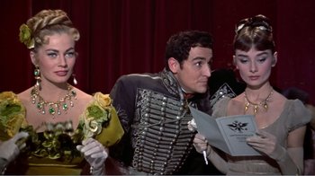 Movie still from “War and Peace” (1956), directed by King Vidor – A group of people sitting next to each other on a stage; Medium shot, Over the shoulder angle