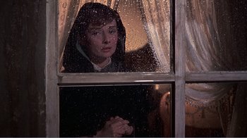 Movie still from “War and Peace” (1956), directed by King Vidor – A woman looking out of a window at night; Medium shot, Over the shoulder angle