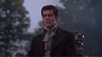 Movie still from “War and Peace” (1956), directed by King Vidor – A man wearing a suit and tie standing in front of a crowd of onlookers; Close Up shot, Over the shoulder angle