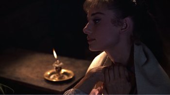 Movie still from “War and Peace” (1956), directed by King Vidor – A woman sitting in front of a lit candle; Close Up shot, Over the shoulder angle