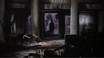 Movie still from “War and Peace” (1956), directed by King Vidor – A man standing in a doorway in an abandoned building; Extreme Wide shot, High angle