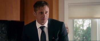 Movie still from “War on Everyone” (2016), directed by John Michael McDonagh – A person wearing a suit and tie; Close Up shot, Over the shoulder angle