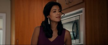 Movie still from “War on Everyone” (2016), directed by John Michael McDonagh – A woman with long black hair wearing a purple top; Close Up shot, Over the shoulder angle