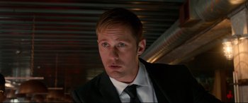 Movie still from “War on Everyone” (2016), directed by John Michael McDonagh – A person wearing a suit and tie; Close Up shot, Low angle