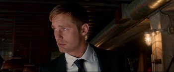 Movie still from “War on Everyone” (2016), directed by John Michael McDonagh – A person wearing a suit and tie; Close Up shot, Over the shoulder angle