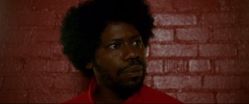 Movie still from “War on Everyone” (2016), directed by John Michael McDonagh – A person wearing a red shirt; Close Up shot, Low angle