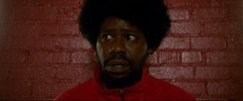 Movie still from “War on Everyone” (2016), directed by John Michael McDonagh – A person wearing a red jacket; Close Up shot, Low angle