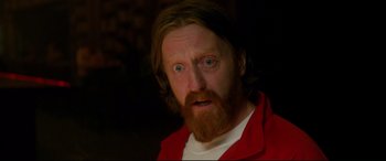 Movie still from “War on Everyone” (2016), directed by John Michael McDonagh – A person with long hair and a beard; Close Up shot, Low angle