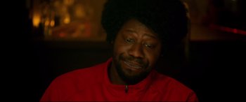 Movie still from “War on Everyone” (2016), directed by John Michael McDonagh – A person wearing a red shirt; Close Up shot, Over the shoulder angle