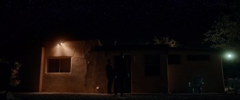 Movie still from “War on Everyone” (2016), directed by John Michael McDonagh – Two people standing outside of a building at night; Extreme Wide shot, Low angle