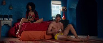 Movie still from “War on Everyone” (2016), directed by John Michael McDonagh – A man sitting on the ground next to a woman; Wide shot, Low angle