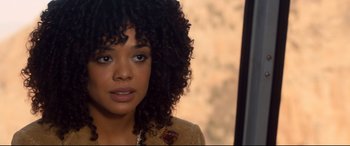 Movie still from “War on Everyone” (2016), directed by John Michael McDonagh – A person with curly black hair; Close Up shot, Over the shoulder angle