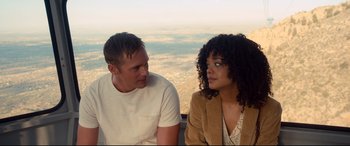 Movie still from “War on Everyone” (2016), directed by John Michael McDonagh – A man and a woman sitting next to each other on top of a hill; Medium shot, Over the shoulder angle