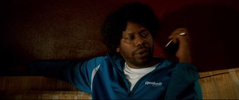 Movie still from “War on Everyone” (2016), directed by John Michael McDonagh – A man in a blue and white jacket looking to his left; Close Up shot, Over the shoulder angle