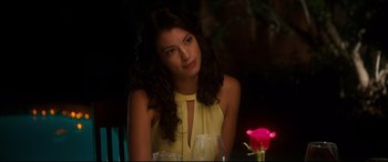 Movie still from “War on Everyone” (2016), directed by John Michael McDonagh – A beautiful young lady sitting at a dinner table; Close Up shot, Over the shoulder angle