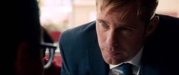 Movie still from “War on Everyone” (2016), directed by John Michael McDonagh – A person wearing a suit and tie; Close Up shot, Over the shoulder angle