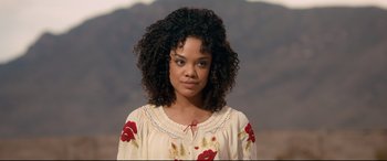 Movie still from “War on Everyone” (2016), directed by John Michael McDonagh – A beautiful young woman with a flower patterned shirt; Close Up shot, Over the shoulder angle