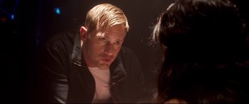 Movie still from “War on Everyone” (2016), directed by John Michael McDonagh – A man with blonde hair looking at a woman in a black jacket; Close Up shot, Over the shoulder angle