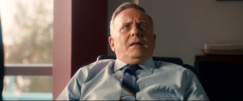 Movie still from “War on Everyone” (2016), directed by John Michael McDonagh – An older man wearing a blue shirt and a blue tie; Close Up shot, Low angle