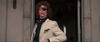 Movie still from “War on Everyone” (2016), directed by John Michael McDonagh – A man in a white suit with a pirate eye patch; Medium shot, Low angle