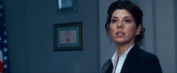 Movie still from “War, Inc.” (2008), directed by Joshua Seftel – A person standing in a room; Close Up shot, Over the shoulder angle