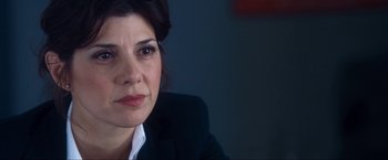 Movie still from “War, Inc.” (2008), directed by Joshua Seftel – A person wearing a suit and tie; Close Up shot, Over the shoulder angle