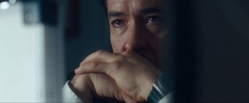 Movie still from “War, Inc.” (2008), directed by Joshua Seftel – A person with his hands over his mouth; Close Up shot, Over the shoulder angle