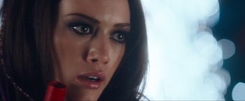 Movie still from “War, Inc.” (2008), directed by Joshua Seftel – A woman's face with green eyes; Close Up shot, Over the shoulder angle