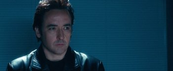 Movie still from “War, Inc.” (2008), directed by Joshua Seftel – A person wearing a black leather jacket; Close Up shot, Low angle