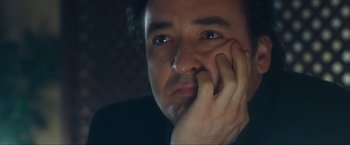 Movie still from “War, Inc.” (2008), directed by Joshua Seftel – A person with his hand on his face; Close Up shot, Low angle