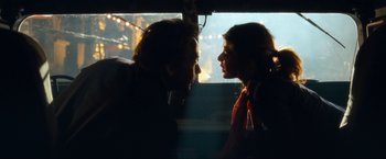 Movie still from “War, Inc.” (2008), directed by Joshua Seftel – A man and a woman looking at one another in a bus; Close Up shot, Over the shoulder angle