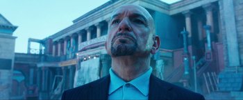 Movie still from “War, Inc.” (2008), directed by Joshua Seftel – A man in a suit and tie looking upward; Close Up shot, Low angle