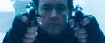 Movie still from “War, Inc.” (2008), directed by Joshua Seftel – A person holding a gun in their hands; Close Up shot, Low angle