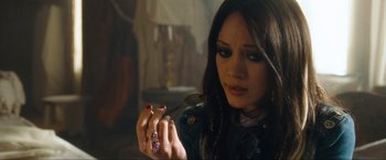 Movie still from “War, Inc.” (2008), directed by Joshua Seftel – A woman holding a cigarette in her hand; Close Up shot, High angle