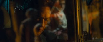 Movie still from “War, Inc.” (2008), directed by Joshua Seftel – A person looking at the camera; Close Up shot, Over the shoulder angle