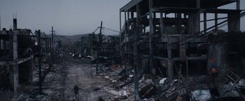 Movie still from “War, Inc.” (2008), directed by Joshua Seftel – A building that has been destroyed in the middle of the night; Extreme Wide shot, High angle