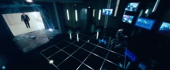 Movie still from “War, Inc.” (2008), directed by Joshua Seftel – A room that has a tv on the floor; Extreme Wide shot, High angle