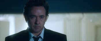 Movie still from “War, Inc.” (2008), directed by Joshua Seftel – A person wearing a suit and tie; Close Up shot, Low angle