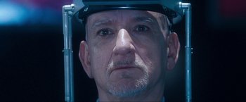 Movie still from “War, Inc.” (2008), directed by Joshua Seftel – An older man wearing a hard hat looking into the camera; Close Up shot, Low angle