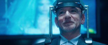 Movie still from “War, Inc.” (2008), directed by Joshua Seftel – A person wearing a suit and tie; Close Up shot, Over the shoulder angle