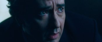 Movie still from “War, Inc.” (2008), directed by Joshua Seftel – A man's face with tears in his eyes; Extreme Close Up shot, Low angle
