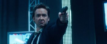 Movie still from “War, Inc.” (2008), directed by Joshua Seftel – A person holding a gun in a room; Close Up shot, Low angle