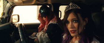 Movie still from “War, Inc.” (2008), directed by Joshua Seftel – A man and a woman sitting in the back of a car; Close Up shot, Over the shoulder angle