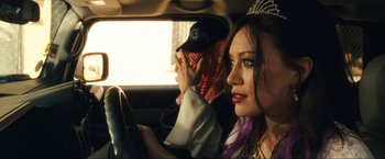 Movie still from “War, Inc.” (2008), directed by Joshua Seftel – A woman sitting in the driver's seat of a car; Close Up shot, Over the shoulder angle
