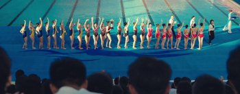 Movie still from “Water Boys” (2021), directed by Haolin Song – A group of women in bathing suits standing in front of a swimming pool; Extreme Wide shot, High angle